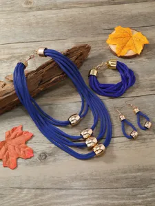 Detailaufnahme des mehrsträngigen blauen Kordel-Schmucksets mit stilvollen goldenen Metallperlen.