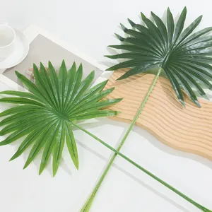 Artificial palm leaf detail closeup, realistic green plant branch for home decor styling.