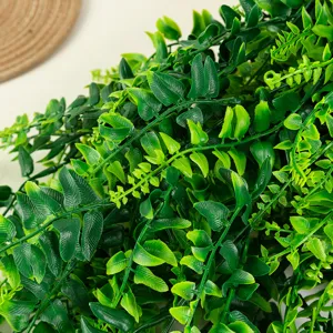 Detailed close-up of artificial boston fern leaves, vibrant green hanging plant foliage decor.