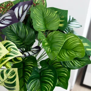Artificial tropical plant leaves detail, lush green monstera and calathea leaves for decor.