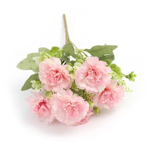 Closeup detail view of artificial pink carnation flower heads with green leaf stems decor.