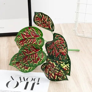 Artificial colorful plant leaves detail shot, vibrant red and green foliage for decor.