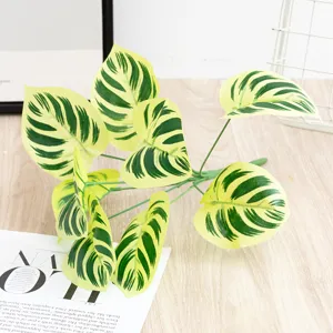 Artificial plant leaves 9-prong green and yellow monstera decor for home and office use.