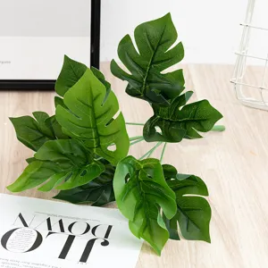 Detailed view of artificial monstera leaves showing realistic texture and green color.