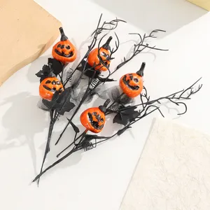 Halloween decoration branch with smiling pumpkins and black maple leaves for party decor detail.