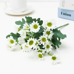Primo piano di mazzo di fiori di margherita bianca artificiale con foglie verdi per decorazione.