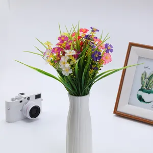 Detailed view of artificial flowers spring grass and small daisies for home decor arrangement.