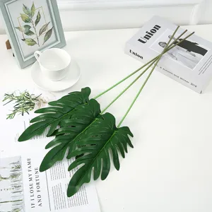 Vista dettagliata di grandi foglie di Monstera artificiali, foglie verdi morbide per decori.
