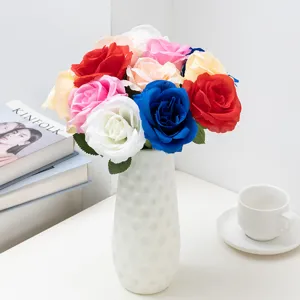Detailed view of colorful artificial rose bouquet in white textured ceramic vase for home decor.
