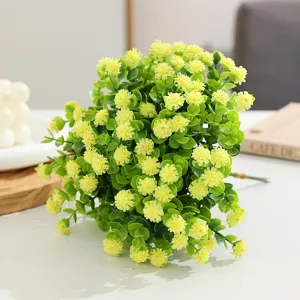 Bouquet de fleurs artificielles d'eucalyptus et jaunes pour décoration de table et vase.