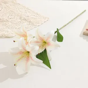 Vista dettagliata di un ramo di giglio artificiale con tre fiori, petali e foglie realistici.
