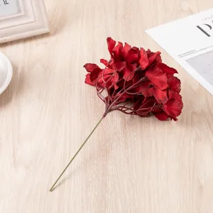 Close-up detail of artificial red hydrangea flower head single silk floral stem prop.
