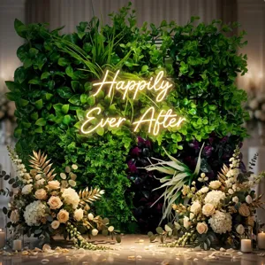 Artificial plant wall backdrop with neon sign and floral decor for wedding party decoration.