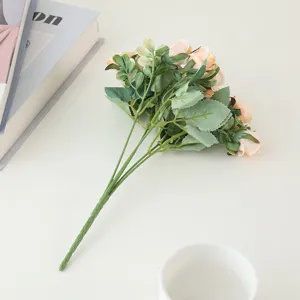 Artificial rose flower bouquet detail, small silk rose blooms with green leaves for floral arrangement.