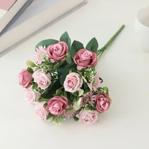 Detailed view of artificial pink silk rose bouquet showing delicate petals and vibrant green leaves.