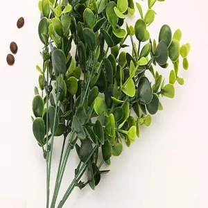 Detailed view of artificial eucalyptus leaves branch, vibrant green foliage for decor.