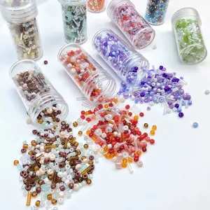 Glass seed beads and bugle beads set in clear bottles for DIY handmade jewelry crafts detail.