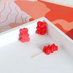Primo piano di perline in acrilico a forma di orsetto rosso in vassoio bianco per gioielli.