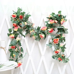 Artificial rose vine detail shot, pink silk flowers on white background for decoration.
