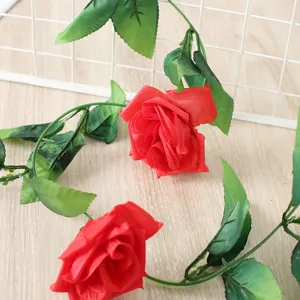Artificial rose flower vine close up, red silk rose garland detail for home wedding decor.