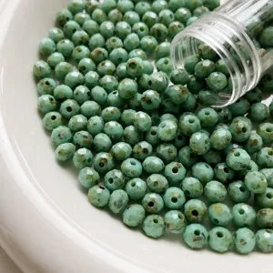 Green faceted Czech fire polished glass beads detail view, 6x5mm size for DIY jewelry making.