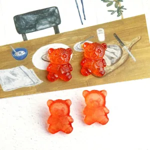 Close-up detail of translucent orange resin bear flatback charms for DIY jewelry and crafts.
