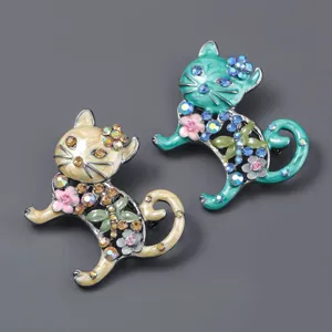 Detailed view of vintage enamel cat brooches featuring sparkling rhinestones and cute floral decor.