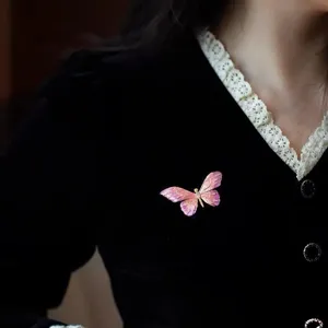 Exquisites Detailbild einer rosa lila Schmetterlingsbrosche aus vergoldeter Emaille und Legierung.