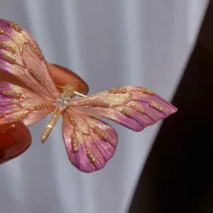 Detailaufnahme der rosa Schmetterlingsbrosche mit feiner Emaillierung und funkelnden Kristallen.