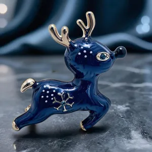 Gros plan de la broche renne de Noël en émail bleu foncé avec des bois dorés brillants.