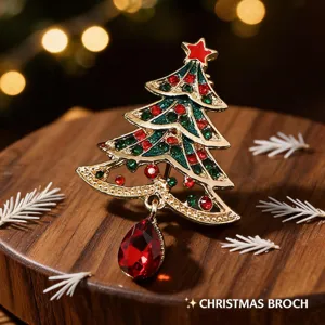 Christmas tree rhinestone brooch detail shot, festive crystal lapel pin with red pendant gem.