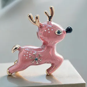 Broche cerf rose en émail de Noël avec cristaux bleus et finition ton dorée élégante