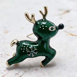 Gros plan détaillé d'une broche renne de Noël festive avec émail vert et détails dorés.
