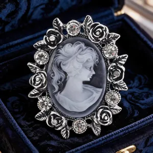 Dettaglio ravvicinato di spilla cammeo vintage con strass brillanti e cornice floreale.
