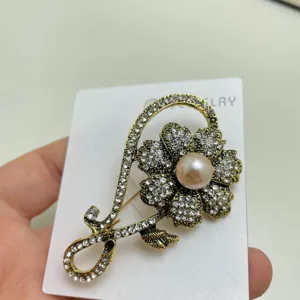 Detailed view of exquisite rhinestone pearl flower brooch, elegant clothing accessory lapel pin.
