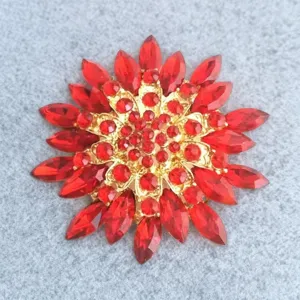 Exquisite red crystal flower brooch, luxury gold tone setting, elegant suit accessory.