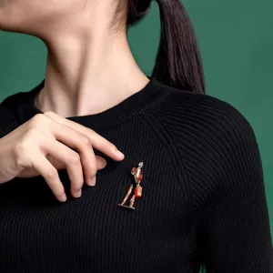 Elegant enamel traveler brooch detail view, stylish fashion accessory for women coats and cardigans.