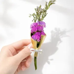 Exquisite gold cone bouquet brooch featuring purple floral design and elegant white bow detail.