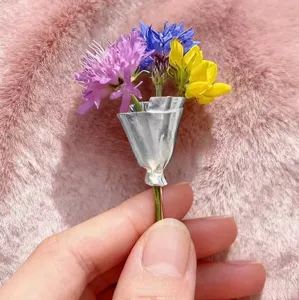 Charming miniature bouquet brooch detail, creative silver foil wrapped flower pin accessory.