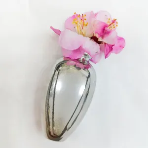 Exquisite silver vase shaped brooch detail, creative floral design accessory for unique style.