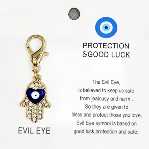Pendentif main de Fatima œil turc en alliage doré avec mousqueton pour sac ou clés.