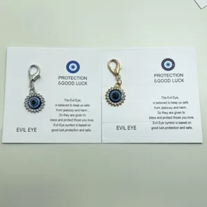 Gros plan de charmants pendentifs strass œil de protection sur carte, accessoire de sac.