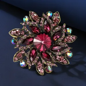 Close-up detail of vintage crystal flower brooch, vibrant rhinestones on gold tone metal.