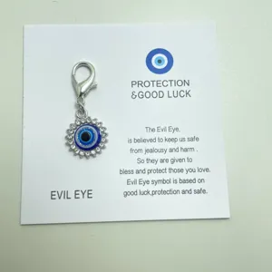 Gros plan sur le charm œil de protection étincelant avec strass et mousqueton sur carte.