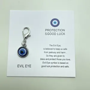 Pendentif en métal œil maléfique avec fermoir mousqueton et carte de vœux détail.