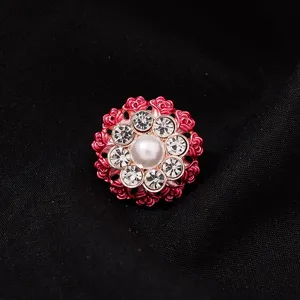 Detailopname van de prachtige strass-bloemkraag decoratieve knoop met een centrale parel.