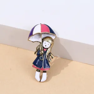 Gros plan détail d'une broche émail fille dessin animé mignon avec parapluie, bijou alliage.