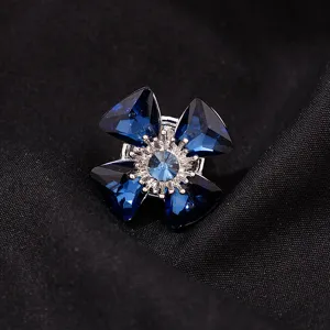 Blauwe kristal bloem broche detail close-up, glanzende strass kraag accessoire.