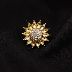 Detailopname van de kristallen zonnebloembroche met gele bloemblaadjes en strass.