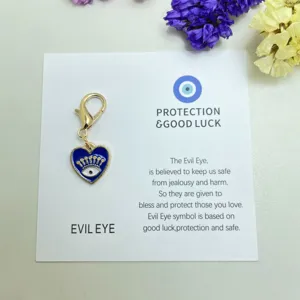 Pendentif grigri œil maléfique en métal en forme de cœur avec fermoir mousqueton sur carte.